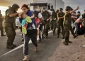 personas caminando ante la vigilancia de la policia