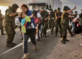 personas caminando ante la vigilancia de la policia