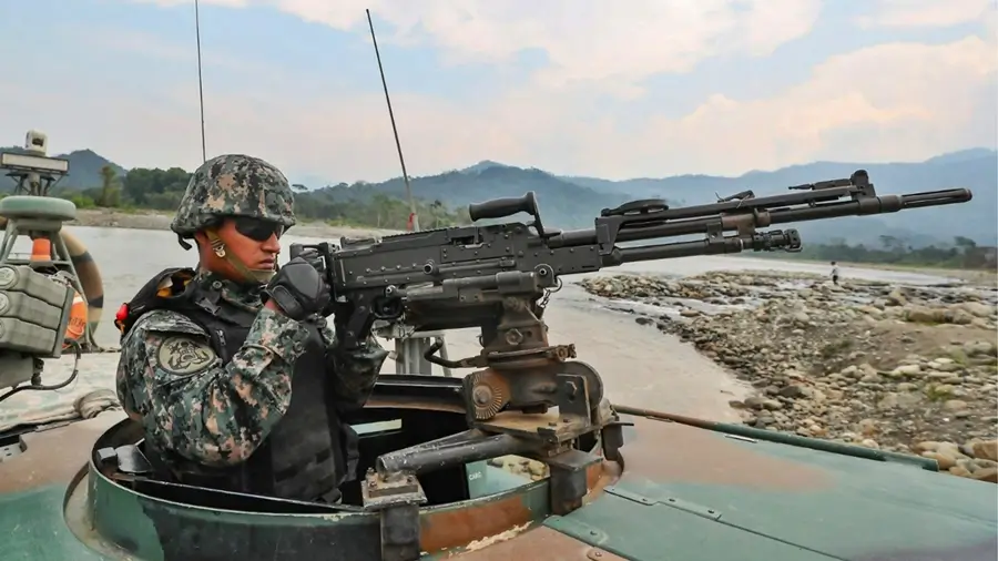 un militar agarrando su armamento, vigilante hacia el horizonte