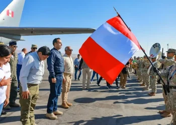José Jerí, presidente del perú mira a militares peruanos que izan la bandera peruana