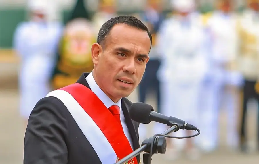 Funcionario peruano con banda presidencial pronunciando discurso oficial durante ceremonia pública