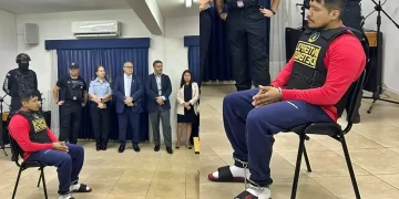 Erick Moreno, alias “el Monstruo”, permanece sentado y esposado durante una presentación oficial de Interpol, con agentes y autoridades detrás, previo a su proceso de extradición al Perú.