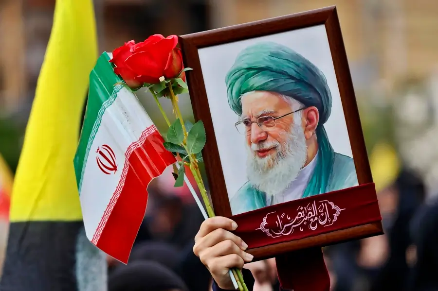 Retrato de líder religioso con turbante verde y bandera de Irán fue sostenido en manifestación.