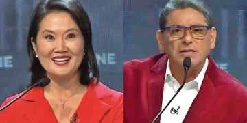 Keiko Fujimori y Carlos Álvarez durante un debate o programa televisivo, ambos usando vestimenta roja y micrófonos de solapa sobre un fondo con pantallas digitales.