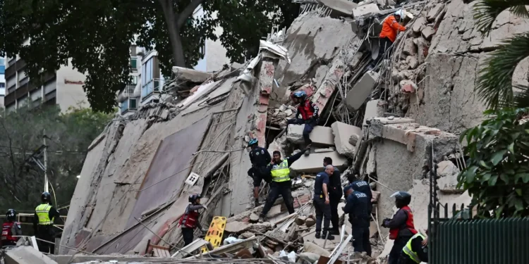 Equipos de rescate y policía trabajando entre los escombros de un edificio colapsado tras un fuerte sismo en Venezuela.