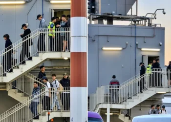 Integrantes del grupo surcoreano BTS bajando por las escaleras en el aeropuerto a su llegada a Lima.
