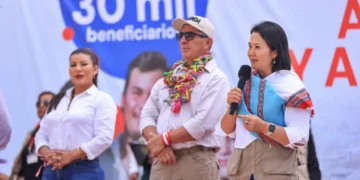 Keiko Fujimori habla por un micrófono sosteniendo una chalina tradicional durante un mitin político.