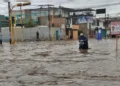 Motociclista avanza por una calle completamente inundada tras intensas lluvias en el norte del Perú.