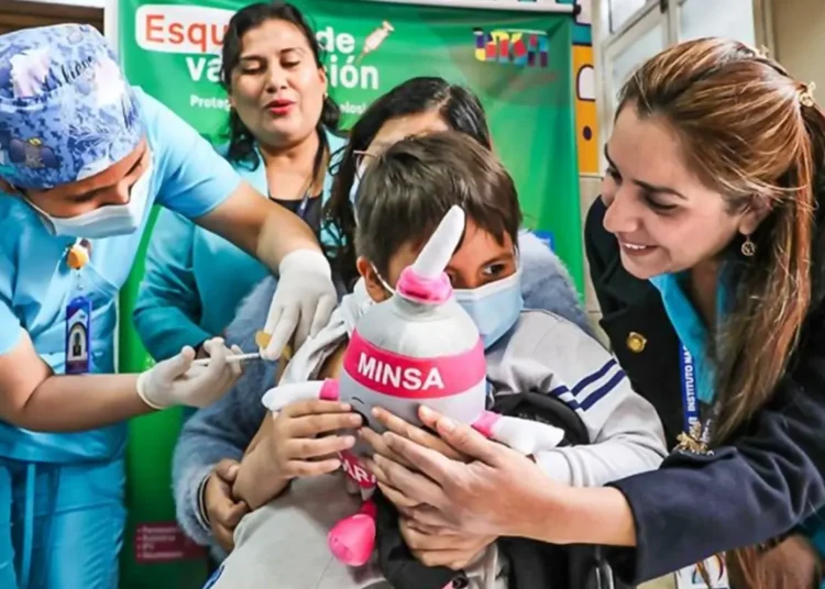 Personal de salud aplicando una vacuna a un niño durante una campaña nacional del Minsa en el Perú